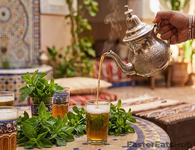 Sweet, strong green tea steeped with fresh mint and poured from height to build a light foam.